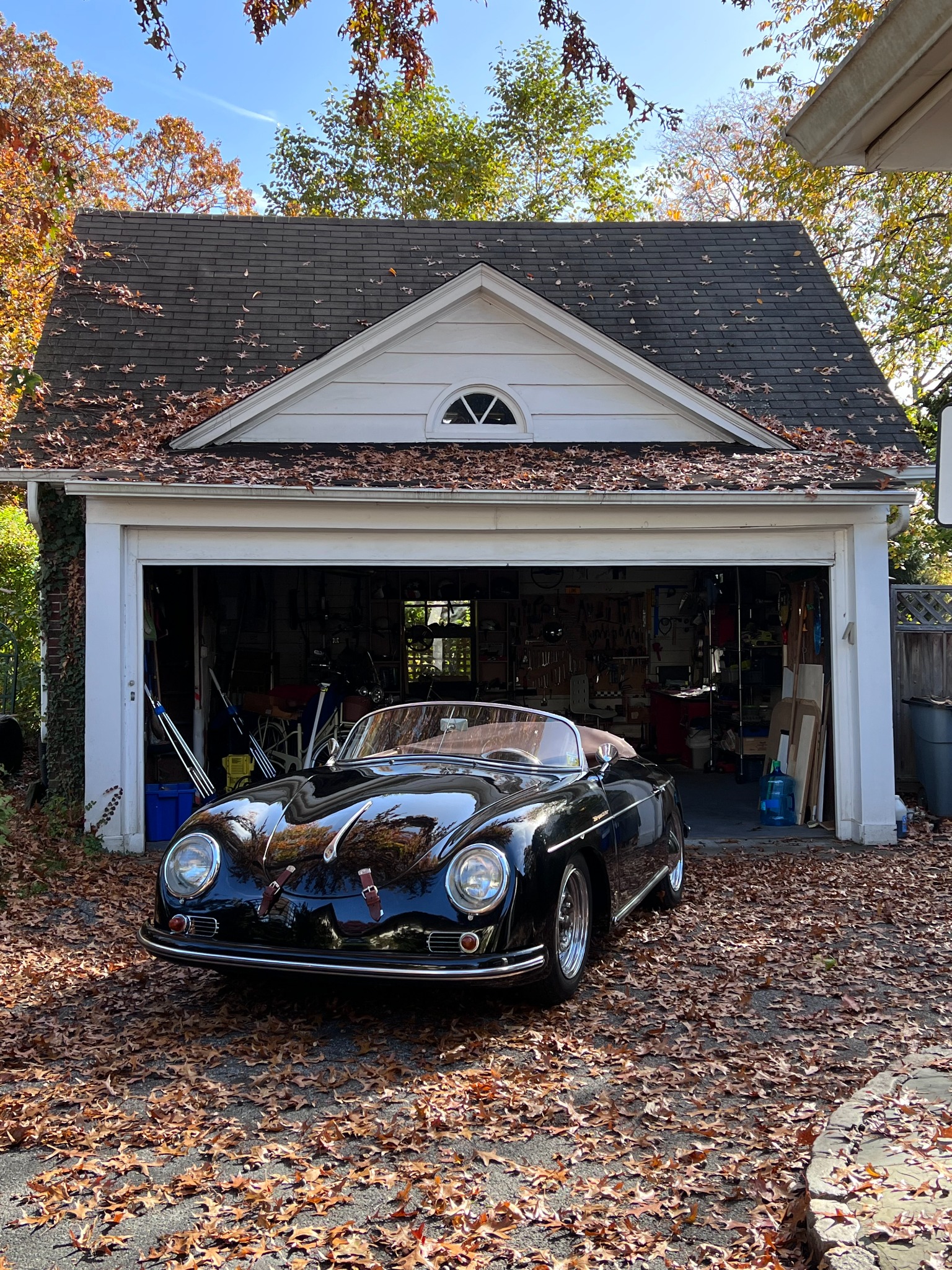 Porsche 356 cabriolet noire devant un garage